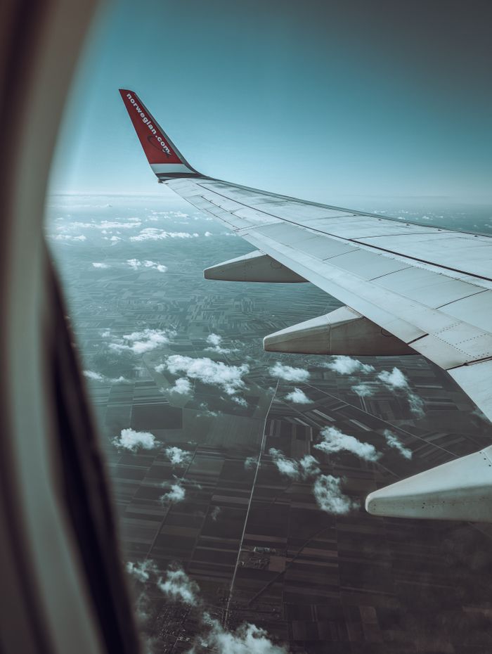 Scenic view of Belgrades landscape through an airplane window, capturing clouds and wing.